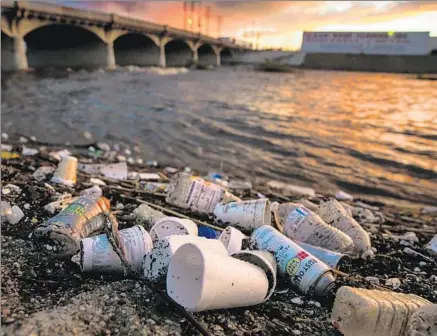  ?? Marcus Yam Los Angeles Times ?? TRASH PILES up on the banks of the Los Angeles River in Vernon after a heavy rainstorm passed through the region Tuesday.