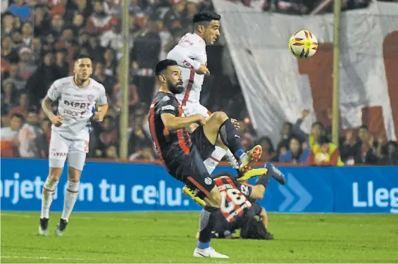  ?? JOSE ALMEIDA ?? Pelea en el mediocampo. Rechaza Ariel Rojas, que anticipa a Nelson Acevedo. A San Lorenzo se le escapó la victoria por poco.