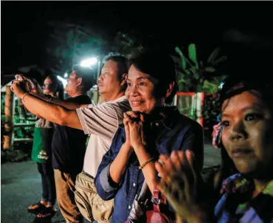  ??  ?? Onlookers cheer as ambulances deliver boys rescued from an air-pocket prison in Tham Luang cave in Thailand to hospital in Chiang Rai last night.