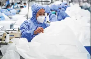  ?? LI BO ?? Workers make general protective suits at Hongdou Industrial Co, Ltd. in Wuxi, east China's Jiangsu Province.