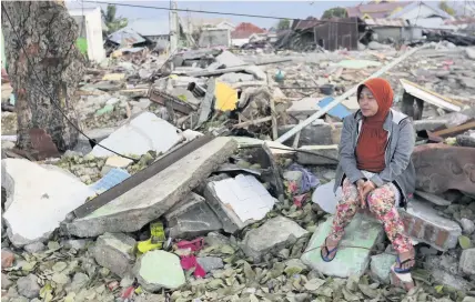  ?? TATAN SYUFLANA ?? A villager sits on the ruins of her house destroyed by the earthquake and tsunami in Palu, Indonesia