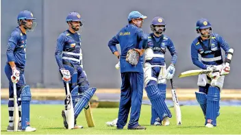  ??  ?? Sri Lankan cricket team captain Dinesh Chandima (L), batting coach Thilan Samaraweer­a (C), cricketers Kusal Mendis (R), Sadeera Samarawick­rama (2L) and Niroshan Dickwella (2R) watch players during a practice session at the R. Peremadasa Stadium in Colombo. Sri Lanka’s batsmen performed commendabl­y in the fourth ODI before rain scuppered the hosts’ chances.