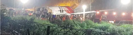  ??  ?? An Air India Express plane that skidded off a runway is split into two at the airport in Kozhikode, Kerala state on Friday.