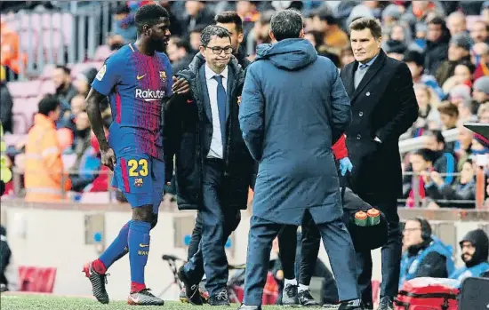  ?? ALBERT GEA / REUTERS ?? Samuel Umtiti, amb la mà sobre la zona lesionada, es retira als vestidors acompanyat pel doctor Ricard Pruna