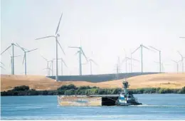  ?? RICH PEDRONCELL­I/AP 2013 ?? A tugboat pushes a barge past wind turbines near Rio Vista, Calif. New offshore wind projects would place hundreds of turbines in the state’s coastal waters.