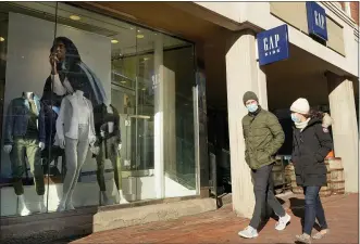  ?? STEVEN SENNE — THE ASSOCIATED PRESS ?? Pedestrian­s outside a Gap clothing store last month in Cambridge, Mass. Analysts say spending should rebound in the spring as the latest round of government stimulus makes its way into consumers’ wallets.