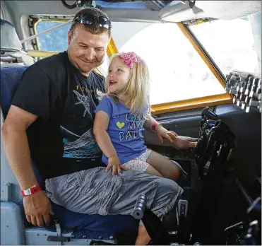  ?? TY GREENLEES / STAFF ?? Isabella Wildman, 3, and her father, Scott, enjoy the KC-135 simulator on Saturday at the air show.