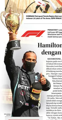  ?? BRYN LENNON/ POOL/AFP ?? PERSISTENT: Lewis Hamilton mengangkat trofi juara GP Inggris di podium Sirkuit Silverston­e tadi malam. Hamilton menang meski bannya pecah di lap terakhir.