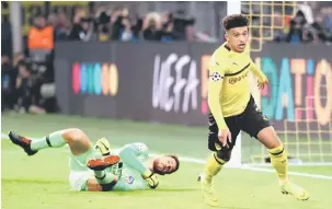  ?? — Gambar Reuters ?? GOL PERTAMA: Sancho (kanan) ceria selepas menjaringk­an gol ketika beraksi pada perlawanan di Dortmund, Jerman Rabu lepas.