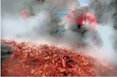  ?? COMMERCIAL APPEAL ?? Tommy Herter with Mudbug Mike’s out of Lafayette, Louisiana, seasons a batch of mudbugs while cooking some 17,000 pounds of crawfish at a recent Rajun Cajun Crawfish Festival. JIM WEBER/THE