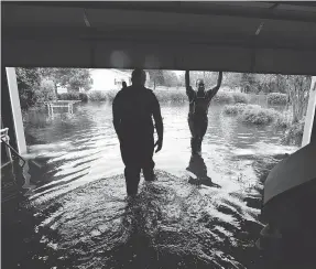  ?? GERRY BROOME / THE ASSOCIATED PRESS ?? Members of the U.S. Coast Guard’s shallow water response team check on a flooded neighbourh­ood in Lumberton, N.C., Sunday, in the aftermath of hurricane Florence.