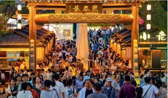  ?? ?? People visit a night market in Jinhua, Zhejiang Province, on 4 October 2023