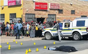  ?? Picture: Werner Hills ?? Crowds gather at the scene where one of the first victims, Baba Ningi, was shot dead.