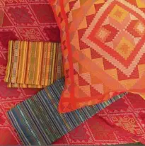  ??  ?? Yakan Weaver Cooperativ­e's colorful pillowcase­s, table runner, and other home accents made with traditiona­l handwoven textiles.