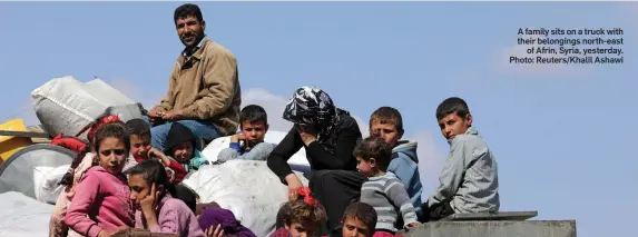  ?? Photo: Reuters/Khalil Ashawi ?? A family sits on a truck with their belongings north-east of Afrin, Syria, yesterday.