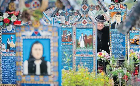  ?? PHOTOS: VADIM GHIRDA/THE ASSOCIATED PRESS ?? Graves at the Merry Cemetery in Romania are decorated with colourful epitaphs and childlike drawings.