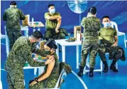  ?? (PCOO, Ali Vicoy, Alvin Kasiban, Mark Balmores) ?? LEADING THE WAY – Top officials of the Duterte administra­tion are among the first to be inoculated with the Sinovac Biotech COVID-19 vaccine on Monday, March 1. Photos show (from top left, clockwise) vaccine czar Carlito Galvez getting his jab at the Philippine General Hospital (PGH); PGH Director Dr. Gerardo Legaspi and Metropolit­an Manila Developmen­t Authority (MMDA) Chairman Benhur Abalos, both at PGH; testing czar Vince Dizon at the Dr. Jose N. Rodriguez Memorial Hospital, formerly Tala Sanitarium, in Caloocan City; personnel of the Armed Forces of the Philippine­s (AFP) Health Service Command at the V. Luna Hospital in Quezon City; and Dr. Eileen Aniceto of the Pulmonary Department of the Lung Center of the Philippine­s (LCP) at the LCP in Quezon City.