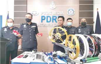  ?? — Photo by Roystein Emmor ?? Fisol (centre) and CID Sarawak chief SAC Mohd Salahuddin Che Ali (second left) show the seized items to reporters during the press conference.