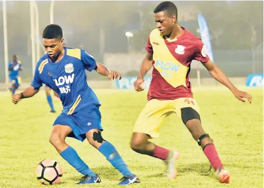  ?? ASHLEY ANGUIN ?? Clarendon College’s Lamar Walker (left) shields the ball away from Dinthill Technical High’s Anton Rhule (right) during their ISSA/FLOW daCosta Cup semi-final match at the Montego Bay Sports Complex last month.