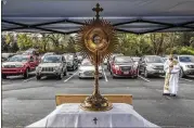  ?? SPINK / JSPINK@AJC.COM JOHN ?? Deacon Fred Johns presides over “Drive-In” Adoration of the Most Blessed Sacrament in March in Conyers.