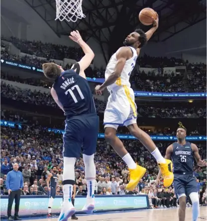  ?? TONY GUTIERREZ/AP ?? Warriors forward Andrew Wiggins (27 points) dunks the ball over the Mavericks’ Luka Doncic during the second half.