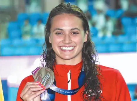  ?? AP PHOTOS ?? Above, Canada’s Kylie Masse poses with her gold medal after winning the women’s 100m backstroke final at the World Swimming Championsh­ips in Gwangju, South Korea, Tuesday. Left, Masse is congratula­ted by compatriot Taylor Ruck of Kelowna after winning the women’s 100m backstroke final.