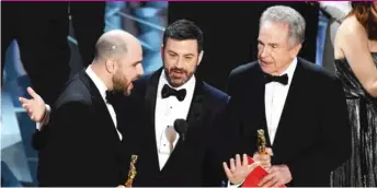  ?? | KEVINWINTE­R/ GETTY IMAGES ?? Host Jimmy Kimmel ( center) reacts as ‘‘ La La Land’’ producer Jordan Horowitz ( left) explains that his film was mistakenly announced as the best picture winner during the 2017 Academy Awards.