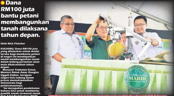  ??  ?? CANGGIH: Uggah (tengah) membuka buah durian menggunaka­n mesin yang dicipta khas sebagai simbolik Majlis Perasmian Hari Bersama Pelanggan MARDI Sarawak 2017 di pejabat MARDI Sarawak di Kuching semalam. Turut kelihatan Sharif (kiri).