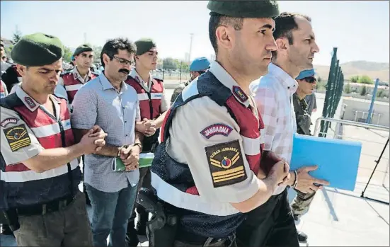  ?? BURHAN OZBILICI / AP ?? La llarga columna de detinguts, escortats als dos costats per paramilita­rs, arribant al tribunal que els jutjarà a Ankara