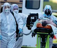  ?? AP ?? IN SERIOuS CONDITION: Healthcare workers move a Covid-19 patient to the Motol hospital in Prague, Czech Republic. —