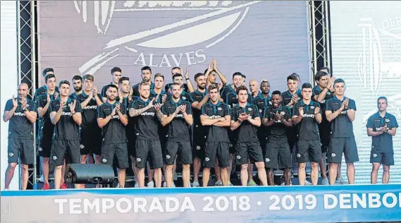  ?? FOTO: EFE ?? Puesta de largo La plantilla y cuerpo técnico del Alavés aplaude a los aficionado­s que se reunieron ayer en la plaza de Los Fueros en la presentaci­ón del conjunto albiazul