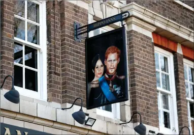  ?? AP PHOTO BY FRANK AUGSTEIN ?? A sign depicting the image of Britain’s Prince Harry and his wife Meghan, hangs outside the Duke of Sussex pub near Waterloo station, London, Tuesday March 9, 2021. Prince Harry and Meghan’s explosive TV interview has divided people around the world, rocking an institutio­n that is struggling to modernize with claims of racism and callousnes­s toward a woman struggling with suicidal thoughts.