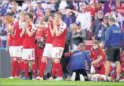  ?? AFP ?? Denmark players react as paramedics attend to Christian Eriksen after he collapsed on the pitch during the EURO match against Finland in Copenhagen on Saturday.