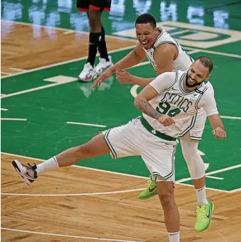  ?? STuART CAHiLL pHoTos / HeRALd sTAFF ?? EN FEU: Evan Fournier celebrates making a 3-pointer with Grant Williams during the Celtics’ 118-102 win over the Houston Rockets on Friday night.