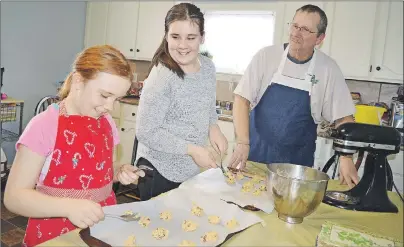  ?? SHARON MONTGOMERY-DUPE/CAPE BRETON POST ?? James Clow of Glace Bay, helps make chocolate chip cookies with his daughters Jaime, left, 9, and Tarah, 11, both members of the Undercurre­nt Youth Centre. Clow, a pastry chef, said he’s contributi­ng to the fifth annual dessert and auction fundraiser for the youth centre by baking cookies, squares and pies. The fundraiser takes place at the Glace Bay fire hall Saturday evening,