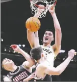  ?? AP PHOTO/MICHAEL CONROY ?? Purdue center Zach Edey (15) gets a dunk over Davidson forward David Skogman (left) and forward Sean Logan in the first half of an NCAA college basketball game in Indianapol­is on Dec. 17, 2022.