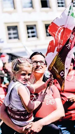  ??  ?? Joline (4) feiert inmitten der Menschenme­nge auf dem Arm ihrer Mutter Sabine den Fortuna Aufstieg.