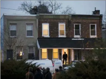  ?? MATT ROURKE — THE ASSOCIATED PRESS ?? A police officer enters a row home to investigat­e a fatal shooting in Philadelph­ia, Monday. Police say two men and two women have been found shot and killed in a basement in Philadelph­ia.