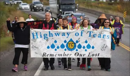  ?? DARRYL DYCK, THE CANADIAN PRESS ?? A group of family members and advocates of missing and murdered Indigenous women and girls walk along the so-called Highway of Tears, in Moricetown, B.C. Gladys Radek organized the walk along the notorious stretch of Highway 16 where dozens have...