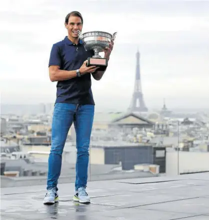  ?? Foto: Efe ?? Nadal, posando ayer con el trofeo en el techo de las Galerías Lafayette, con la torre Eiffel al fondo.