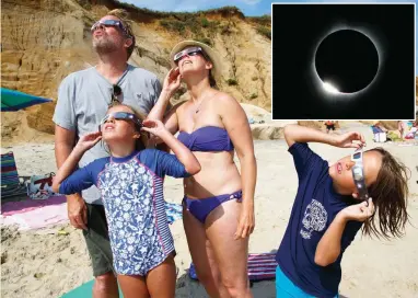  ??  ?? SILVERY RING – The Powell family, from Albany, New York, gazes in awe at the solar eclipse (inset photo) as seen from a beach in Chilmark, Massachuse­tts, in the United States last August 21. (EPA/Justin Lane)