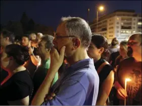  ??  ?? People gather with candles outside the Greek Parliament in Athens, on Monday in memory of victims of a deadly wildfire a week ago. More than 90 people died in the fire that gutted resorts east of Athens, the deadliest Greek fire in recent history. AP...