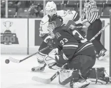  ??  ?? Royals captain Matthew Phillips tries to corral a rebound in front of Rebels goaltender Riley Lamb on Friday night.