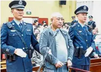  ?? — AFP ?? Agent of death: Gao flanked by two policemen at the court in Baiyin in March last year.