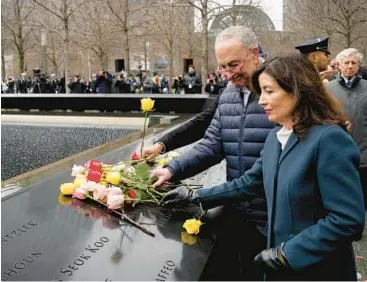  ?? JOHN MINCHILLO/AP ?? Sen. Chuck Schumer and New York Gov. Kathy Hochul place flowers Sunday for the 1993 bombing victims.