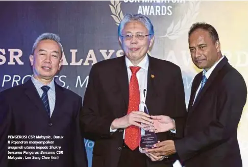  ??  ?? PENGERUSI CSR Malaysia , Datuk R Rajendran menyampaik­an anugerah utama kepada Shukry bersama Pengerusi Bersama CSR Malaysia , Lee Seng Chee (kiri),