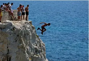  ?? (Jean-Paul Pelissier/Reuters) ?? A teenager dives into the Mediterran­ean Sea – which isn’t as old as it looks.