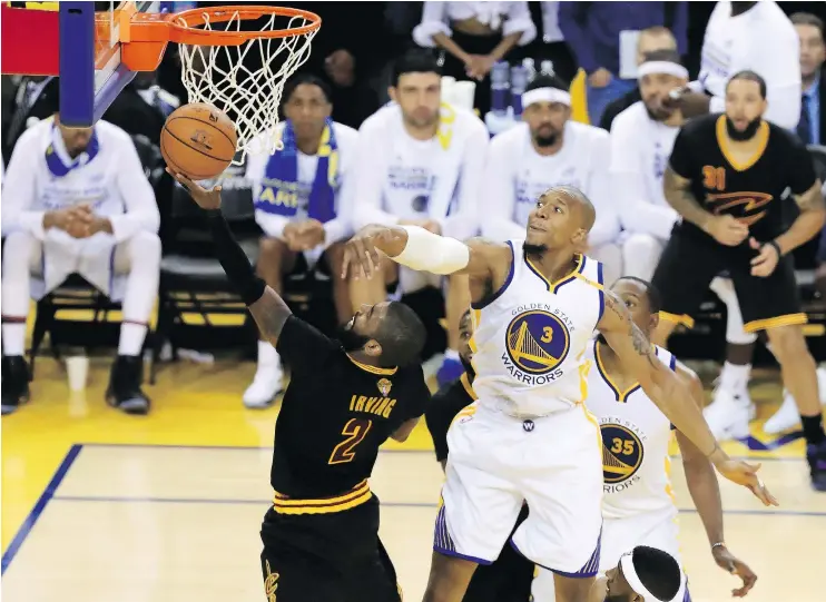  ?? — GETTY IMAGES ?? Cleveland’s Kyrie Irving throws up a shot against the Warriors’ David West during Game 2 of the NBA Finals Sunday. The Warriors won 132-113 to take a 2-0 series lead.