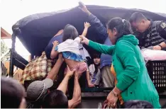  ??  ?? MANILA: Residents are assisted into a truck after the local government implemente­d preemptive evacuation­s at Barangay Matnog, Daraga, Albay province yesterday due to the approachin­g typhoon Nock-Ten. —AFP