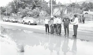  ??  ?? SAMSUDIN bersama pegawai JKR, JPS dan MPS meninjau keadaan sistem perparitan yang menyebabka­n air bertakung dan berlakunya banjir di Jalan Lintas Sibuga.